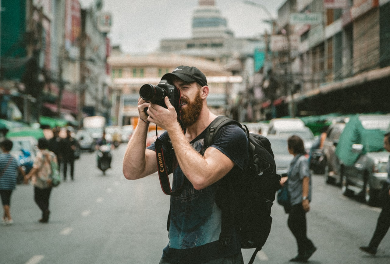 A photographer holding a camera on a city street